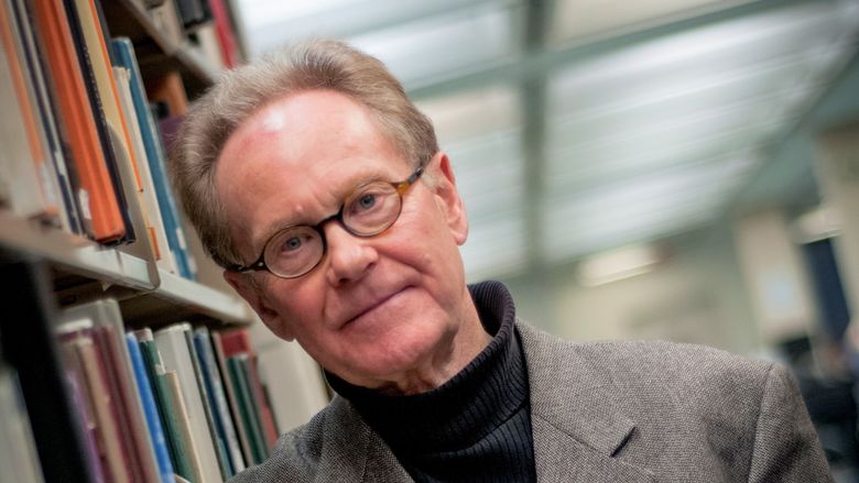 Dr. Phil Mosley in library holding book