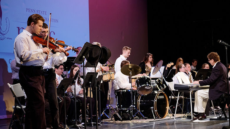 Group of students playing musical instruments on stage
