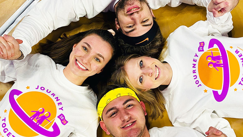 The dancers lying on the floor in a circle holding hands