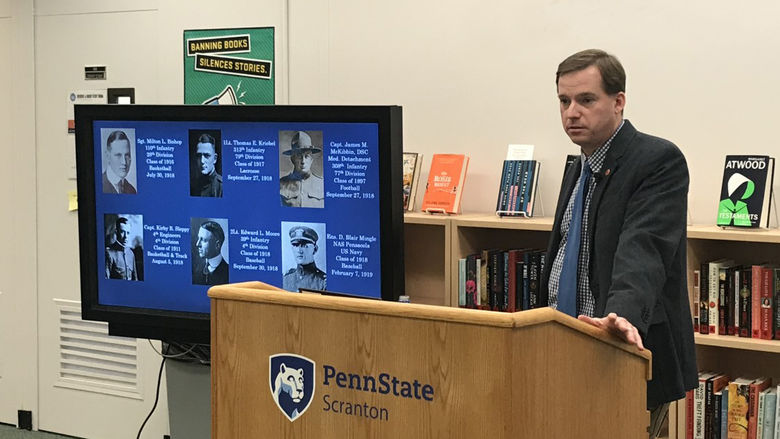 Ken Hickman, director of the Penn State All-Sports Museum stands at podium in library