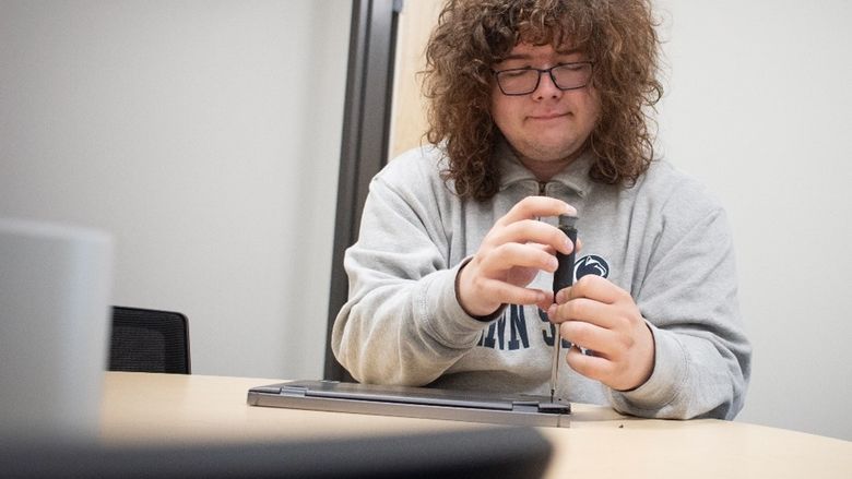 IT student worker Adam horan works on a computer keyboard