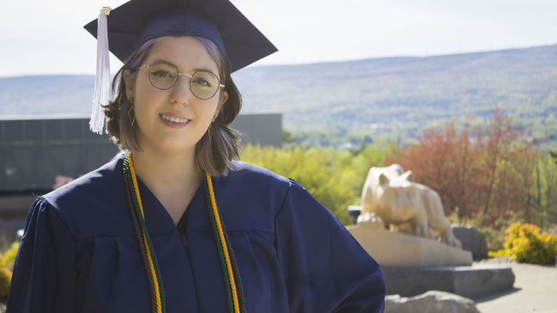 Student wearing commencement regalia and smiling