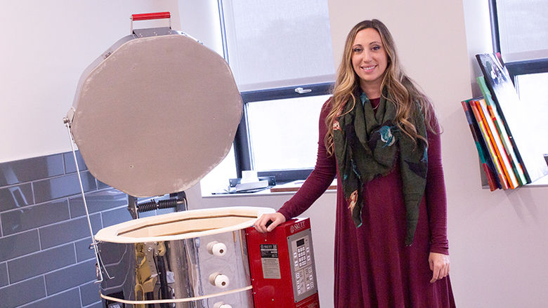 Lecturer in Art, Corianne Thompson stands near kiln in the new art studio 