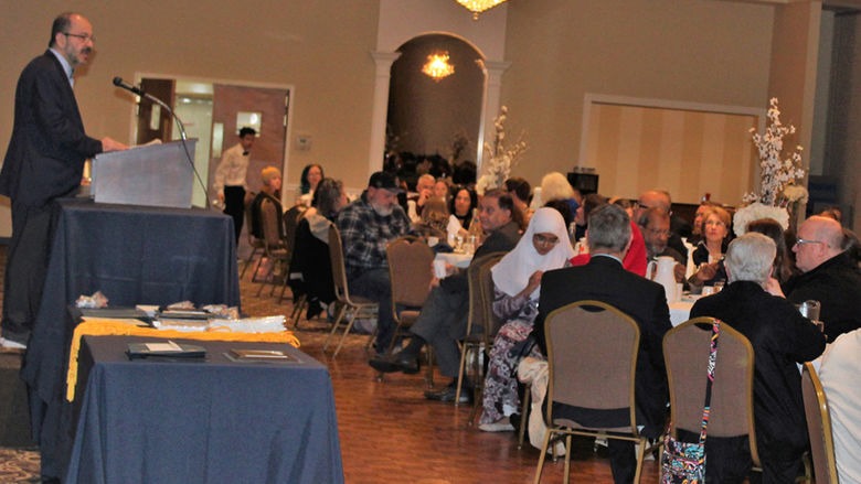 Chancellor Wafa speaks at podium to crowd