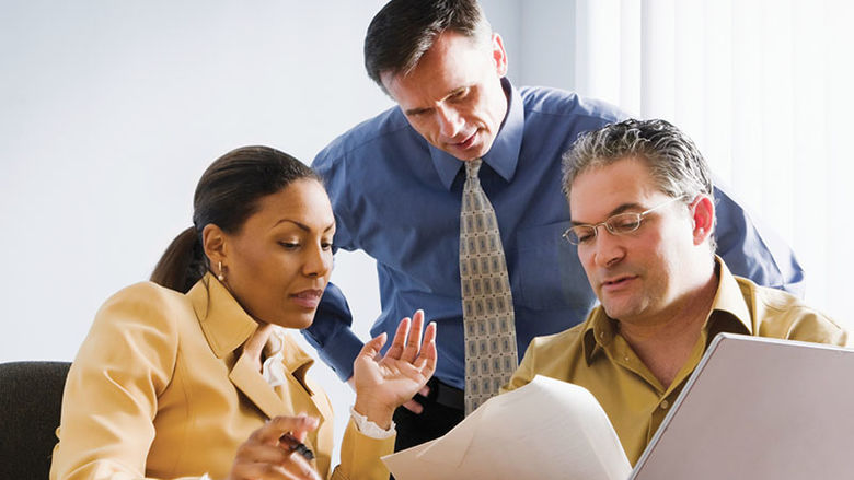 three working professional at a laptop
