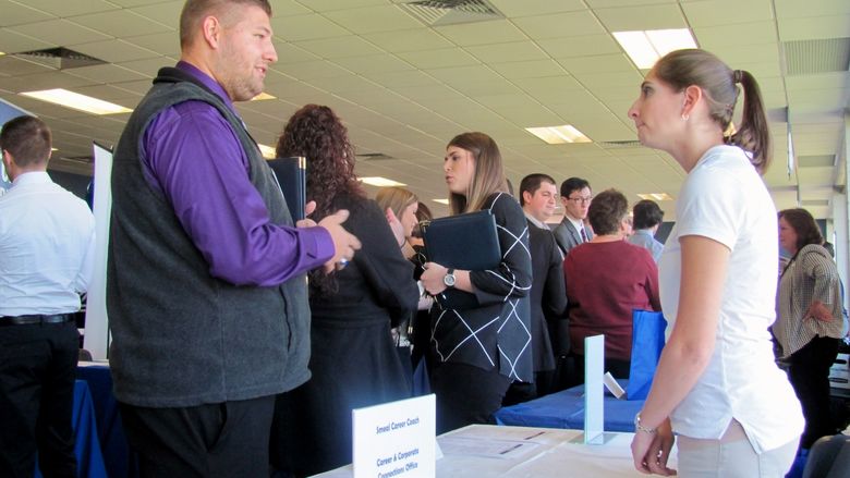 A student attending the Penn State Northeast Region Career Expo talks with a company representative.