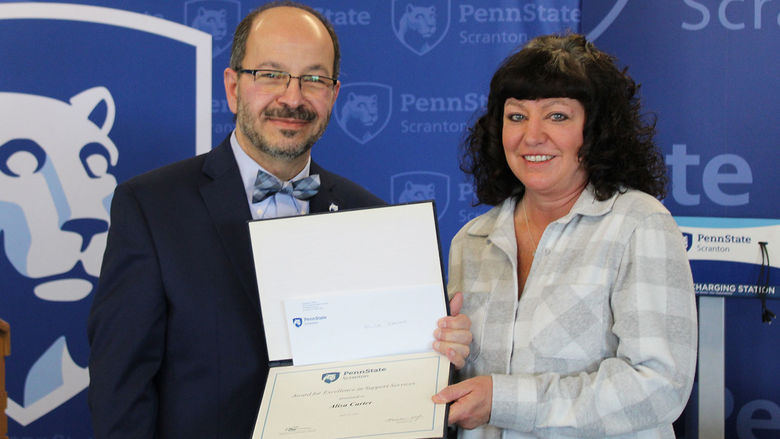 smiling dr. wafa presents a certificate to Alisa Carter