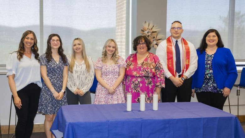 group of honor society inductees pose for a picture at the induction ceremony