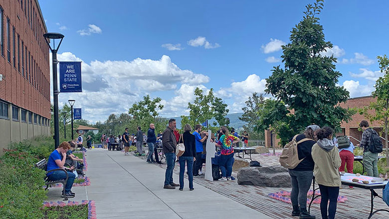 groups of people at various tables at a fair on the patio