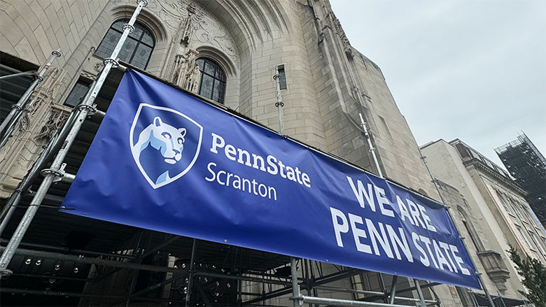 we are penn state banner on side of large stone building