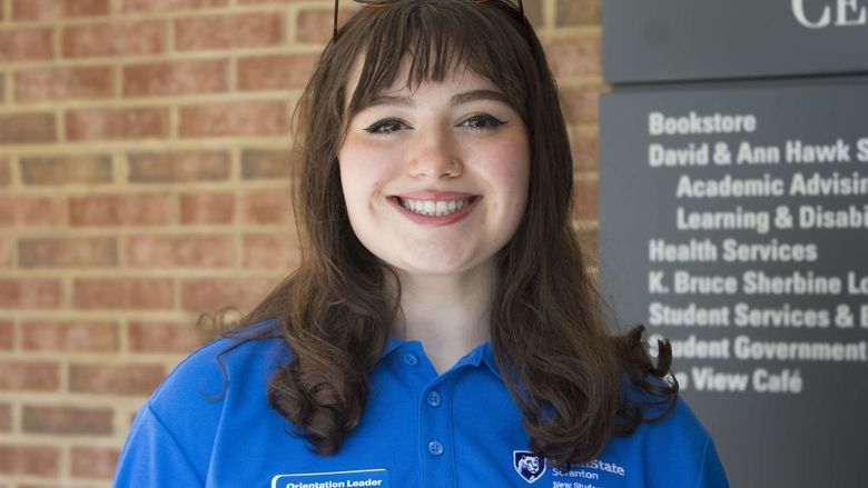 Student smiling stands in front of building that reads 'Study Learning Center'