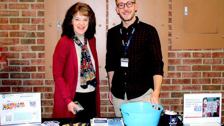 Disability services director Eileen Giovagnoli and Matt Smith man a table with information on disability services