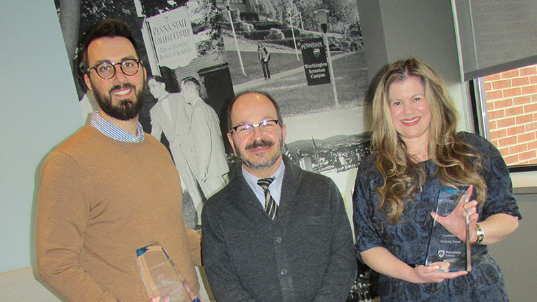 Two award winners holding their trophies, pictured with the Chancellor.