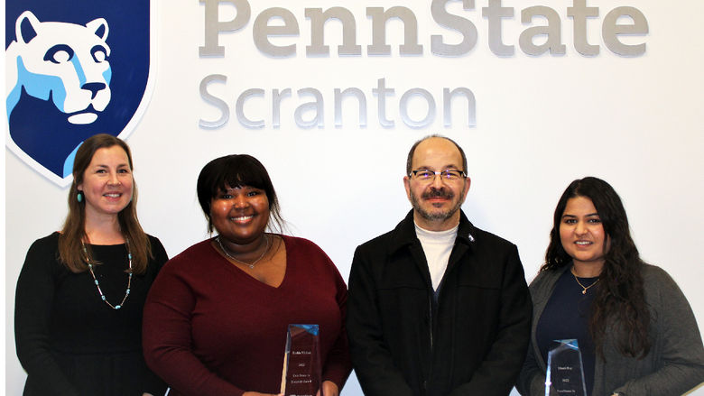 Chancellor Marwan Wafa poses for a photo in front of Penn State Scranton logo on wall with Diversity award winners