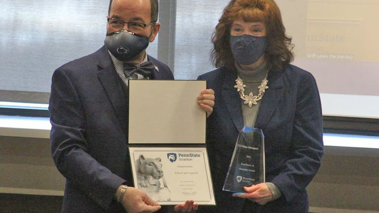man hands woman an award and certificate