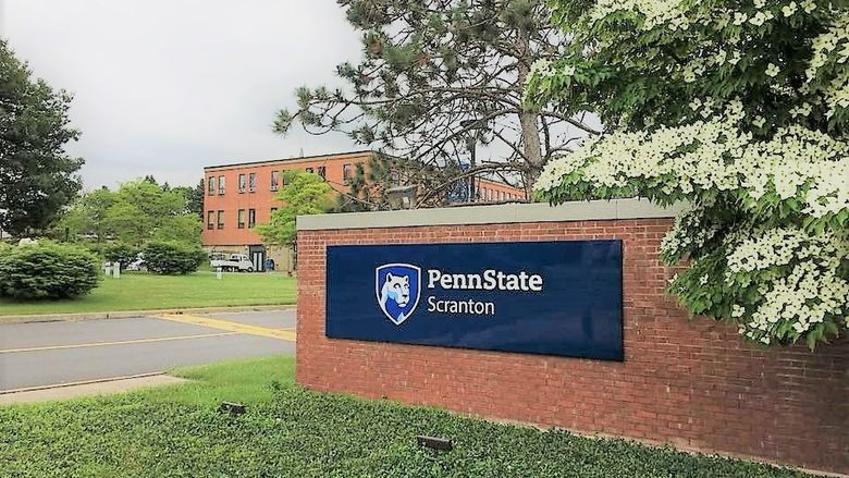 entrance to the campus with the red brick entrance sign reading Penn State Scranton and campus logo