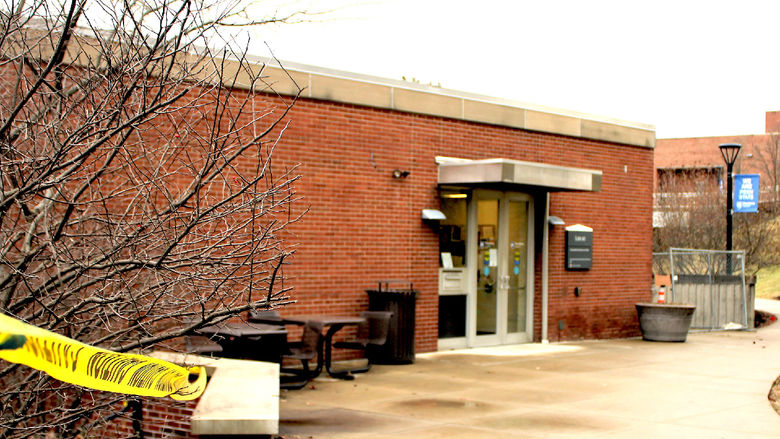 construction tape cordons off campus library entrance at start of renovation project