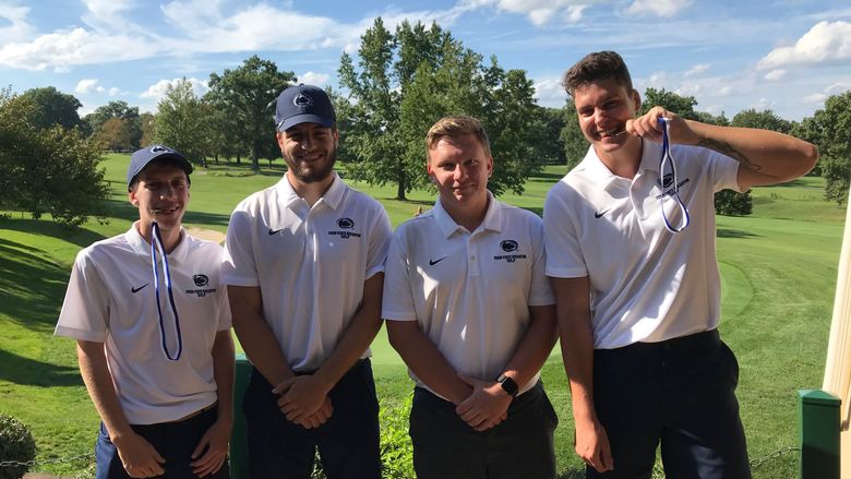 Golf team members pose for a photo on the golf course