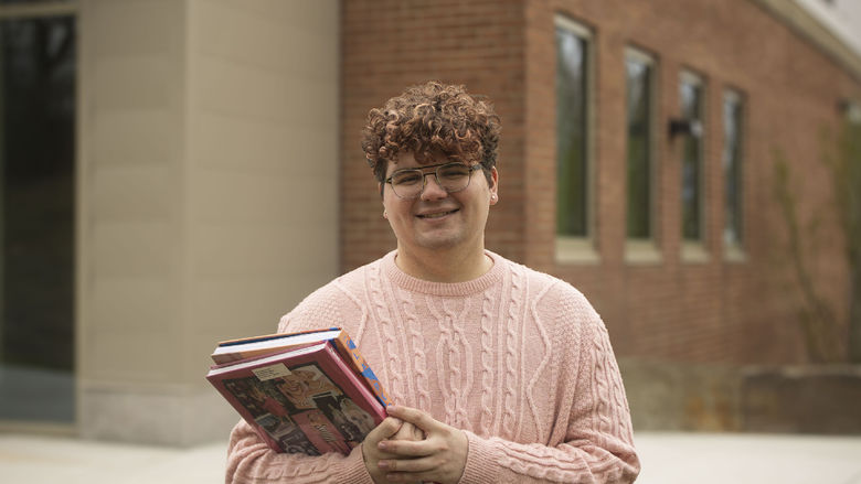 photo of Grant Loose in front of library building holding a padfolio
