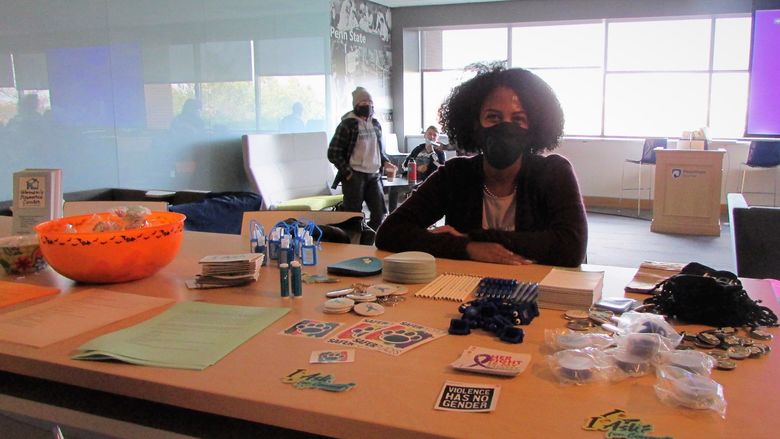 Nuris Perdomo sits at an information table at the domestic violence awarness event in the Sherbine Lounge