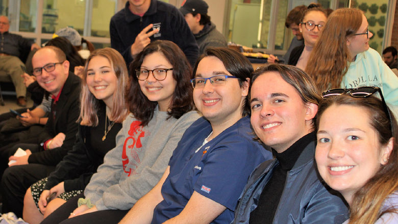 group of students seated side by side smile for the camera prior to the start of the GPA Celebration