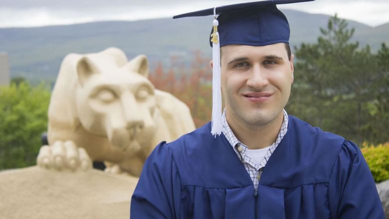 Student wearing commencement regalia and smiling