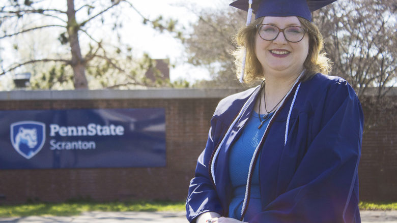 Student wearing commencement regalia and smiling