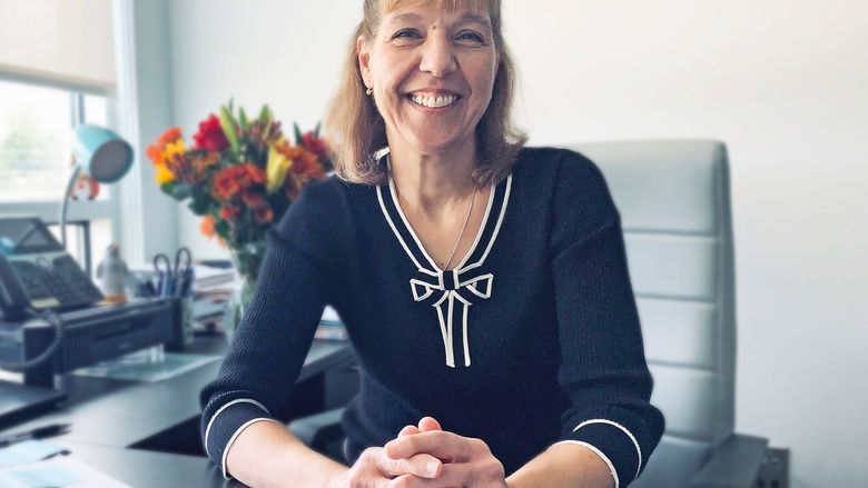 Jo Ann Durdan smiling, seated at her desk