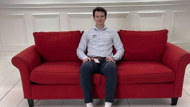 A student sits on a red couch