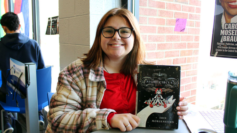 Student Kiera Langan smiles while showing off her book of choice "The Night Circus".