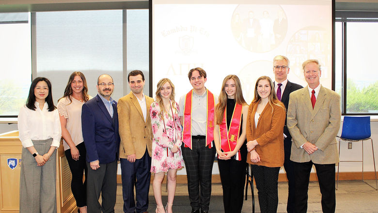 new inductees into lamda pi eta pose for a group photo