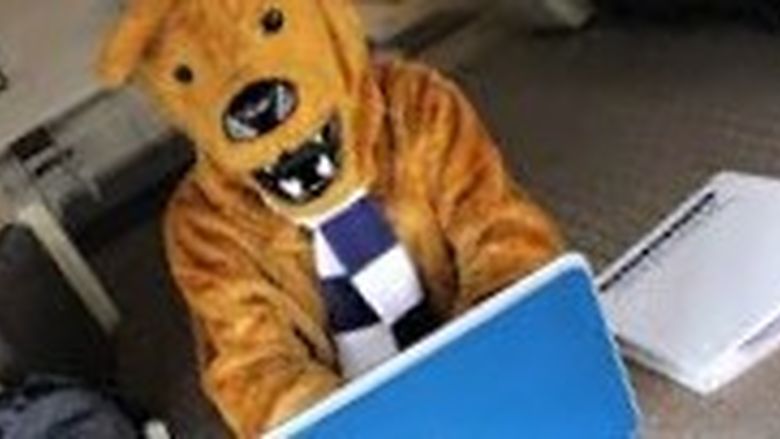 Nittany Lion sitting at laptop