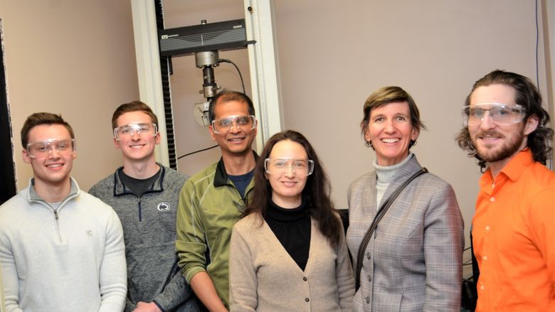 Lockheed martin group pose for a photo with equipment they used in experiment
