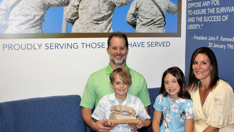 campus donors E.J. and Aryn Long, sit on a sofa in the new Penn State Scranton Veterans Lounge with their children, Addison and Parker