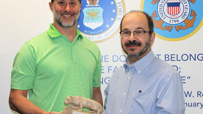 Campus alumnus EJ Long, at left, receives a Nittany Lion Shrine statue from campus Chancellor Marwan Wafa during a tour of the newly created Veterans Lounge he donated to. 