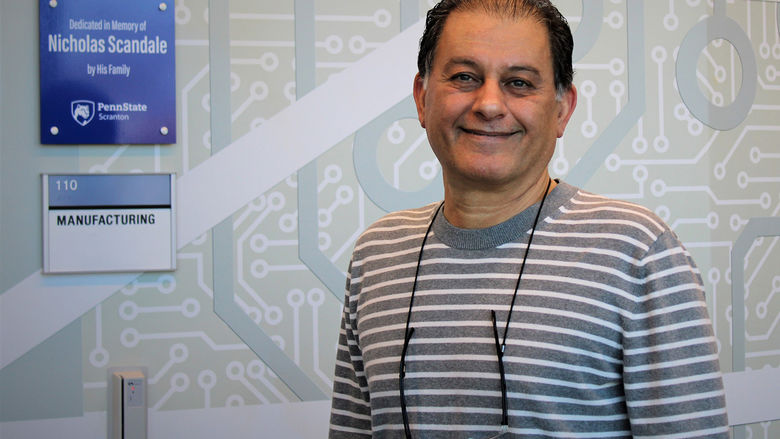 Majid Chatsaz stands at entranceway of the manufacturing lab in the engineering Building