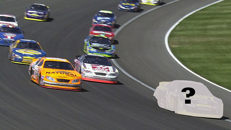 group of race cars speed round the turn on a race track
