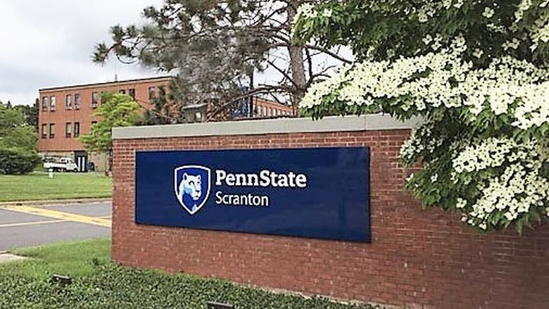 Front entrance to campus with brick wall and sign