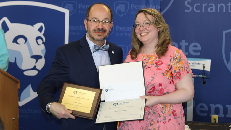 smiling man presents certificate to smiling woman