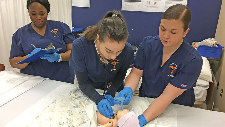 # nursing student work with baby robotic in sim lab