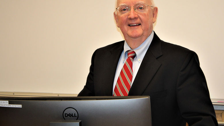 Pat Sheridan standing at Lectern in classroom