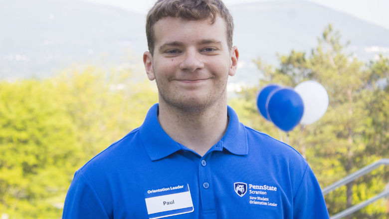 NSO Leader, Paul, smiles with balloons in the background. 