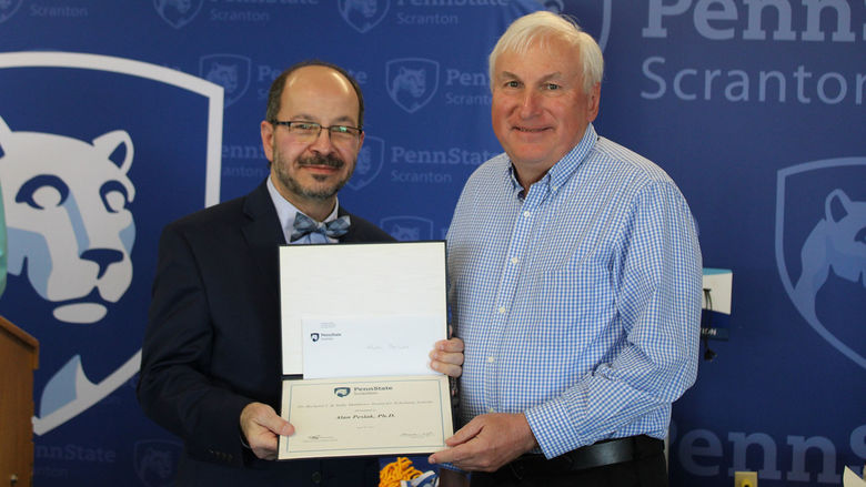 smiling man presents certificate to smiling man