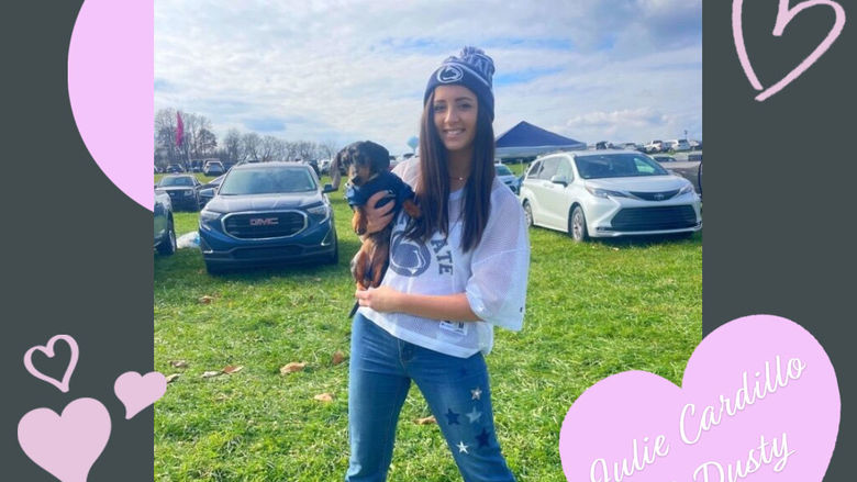 girl in penn state gear holds her mini dachshund puppy