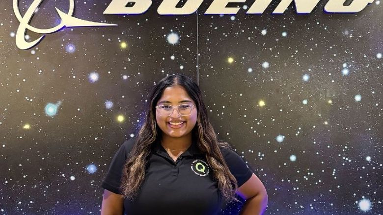 A student stands in front of a Boeing sign