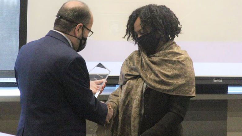 man hands woman an award