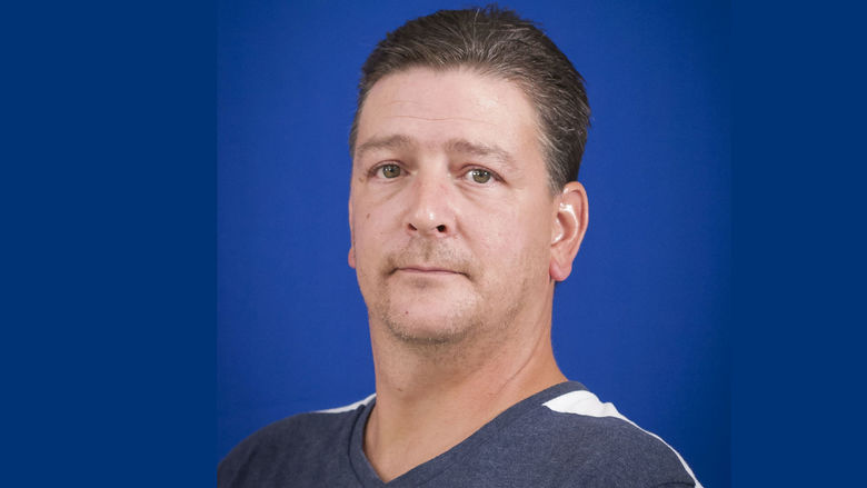 headshot of Wayne Reesey wearing blue and white striped shirt