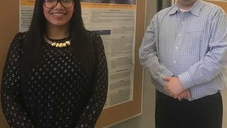Student Brittany Hebron standing near her poster with her advisor, Dr. Michael Evans, at the Penn State Eastern Regional Undergraduate Research Symposium at Penn State Hazleton, 2019