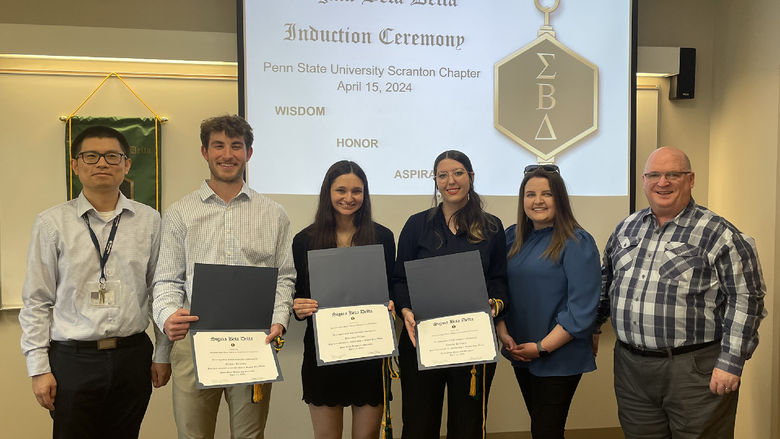 new inductees pose for a photo with faculty and honor society members