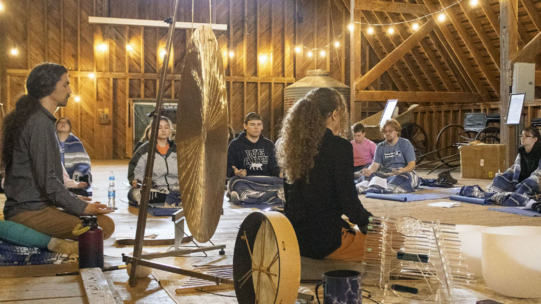 a group of students take part in sound meditation in the Fullers Overlook barn building